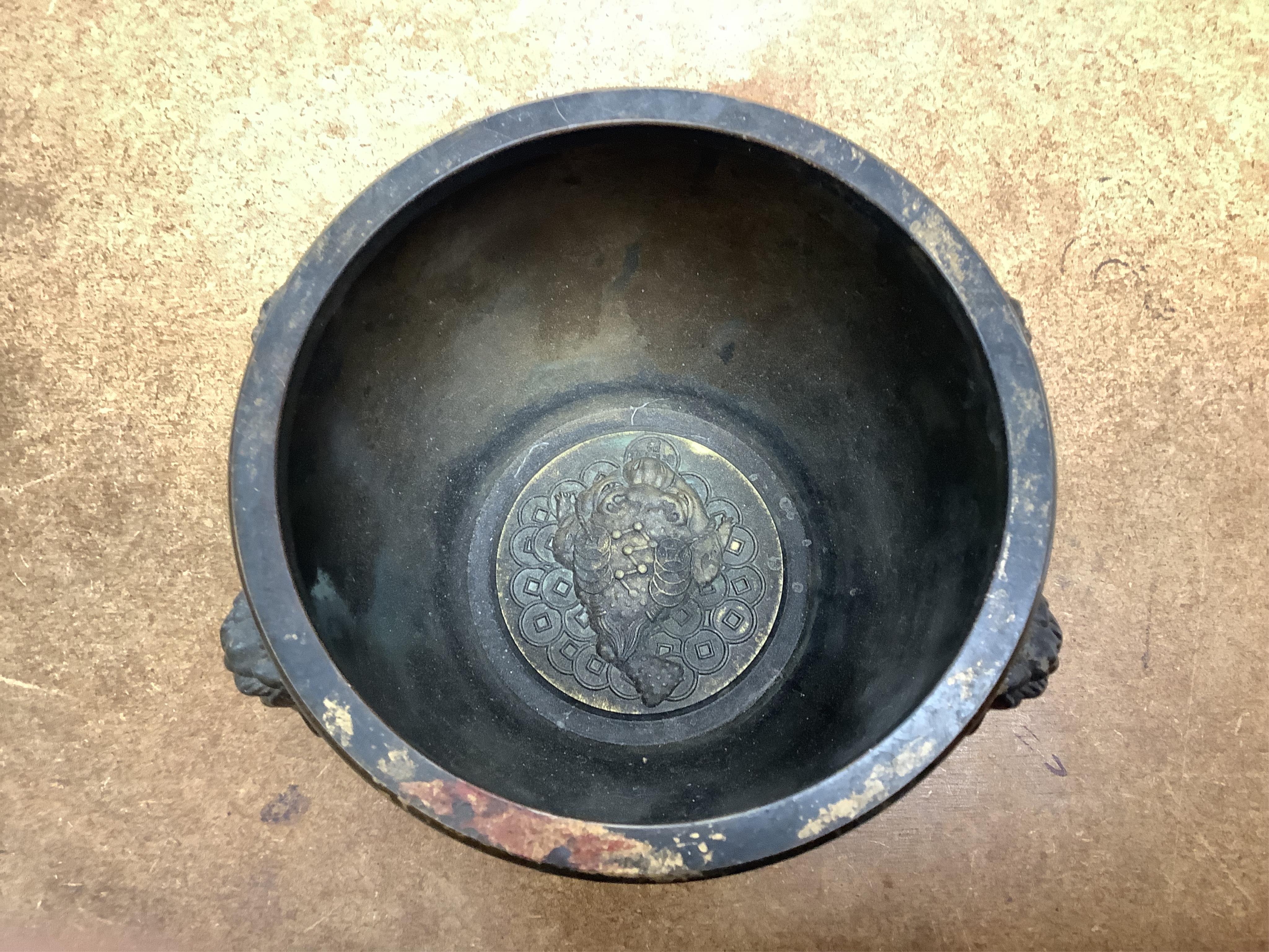 A Chinese partially gilt bronze censer, decorated in relief with twin handles, 16cm in diameter